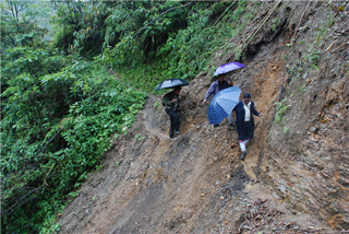 高德荣常年不顾下雨塌方危险徒步奔走于独龙江乡高山峡谷。