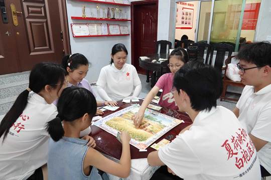 图为大家围坐桌前玩桌游，在欢声笑语中读懂四季农耕